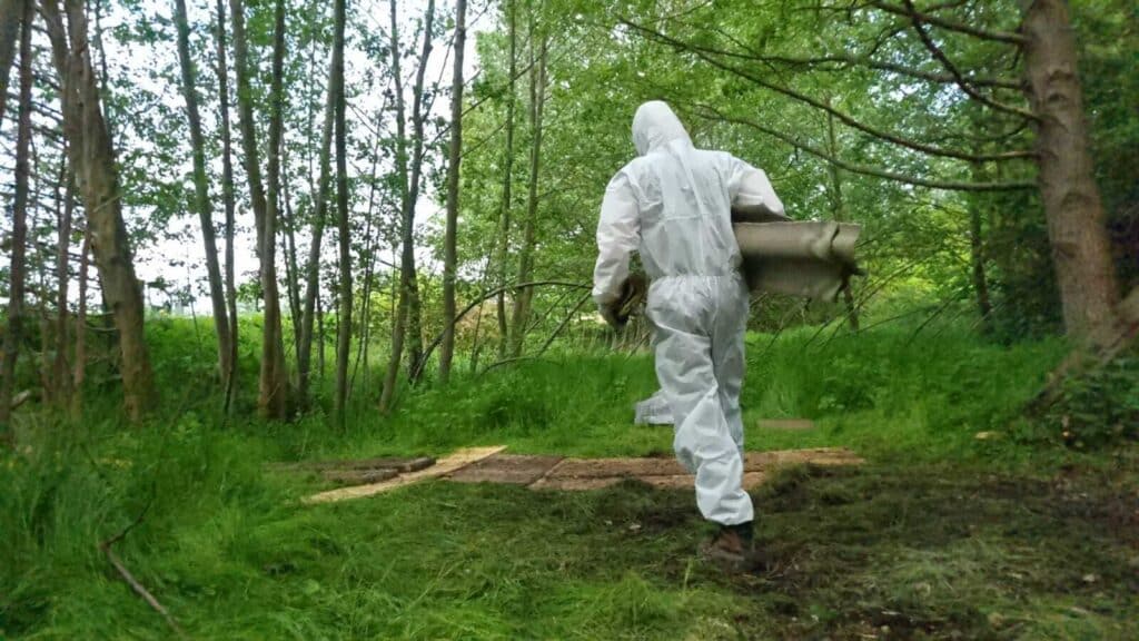 Professionelle Entsorgung und Transport von Asbest durch Person in Schutzanzug
