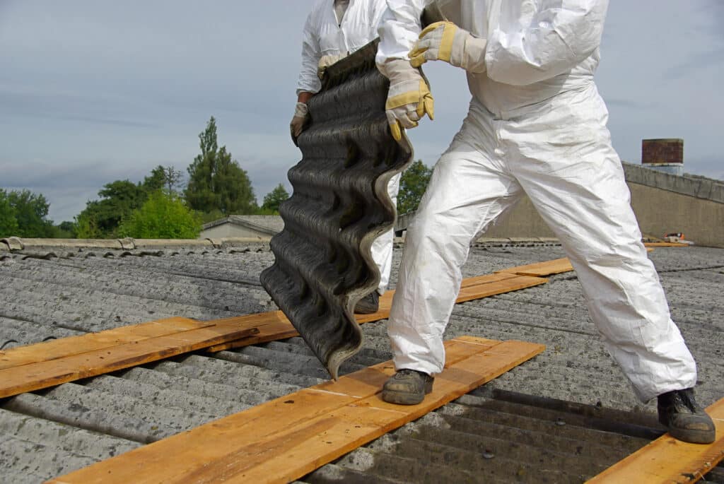 Entfernung von Asbest durch Arbeiter in Schutzkleidung