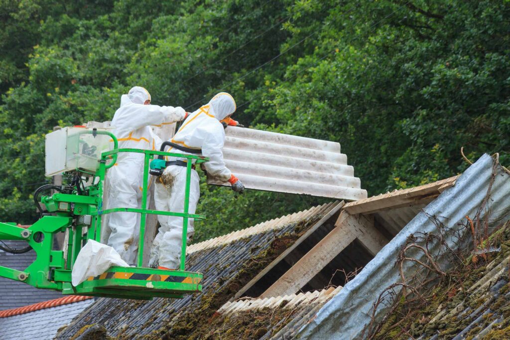 Asbestentfernung: Entfernung eines Asbestdachs durch Professionelle Arbeiter in Schutzanzügen