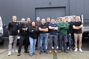 Das Team der Obolus Group mit Firmenfahrzeugen