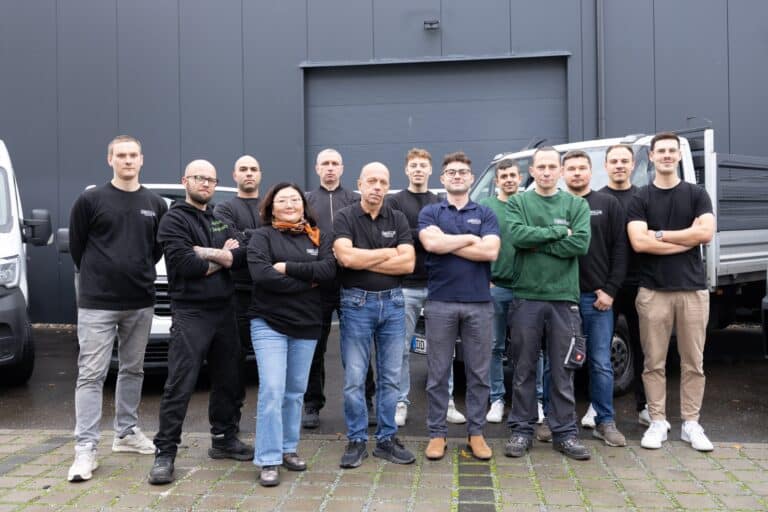 Das Team der Obolus Group mit Firmenfahrzeugen